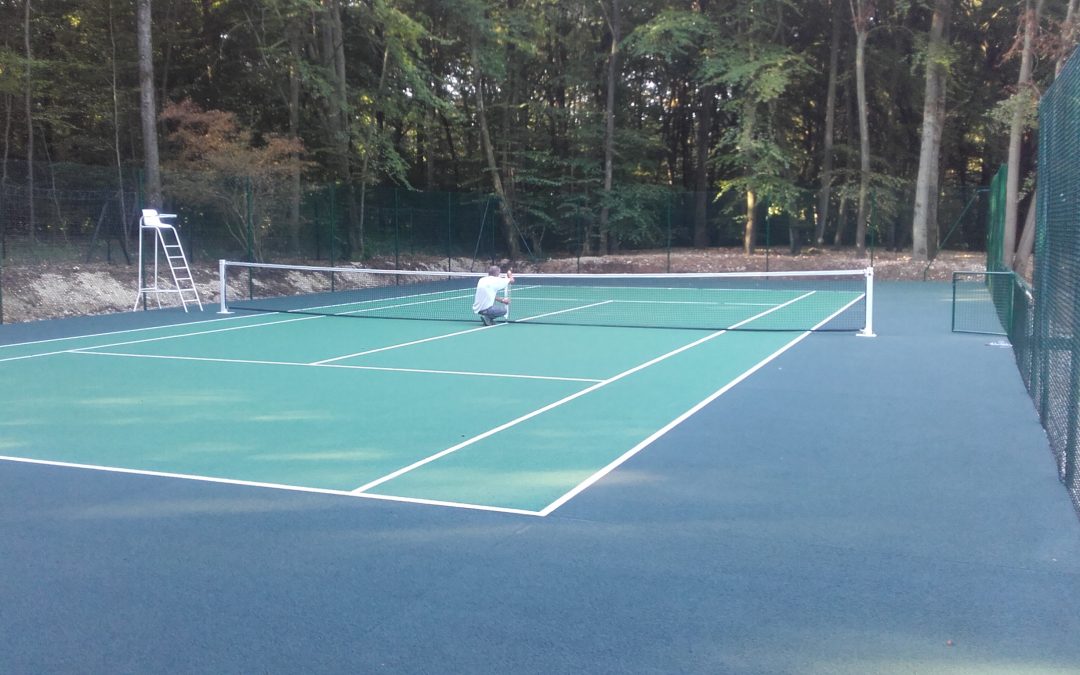 Construction d’un court de tennis en béton poreux avec clôture surbaissée à Menilles
