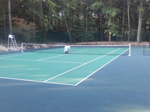 Construction d’un court de tennis en béton poreux avec clôture surbaissée à Menilles